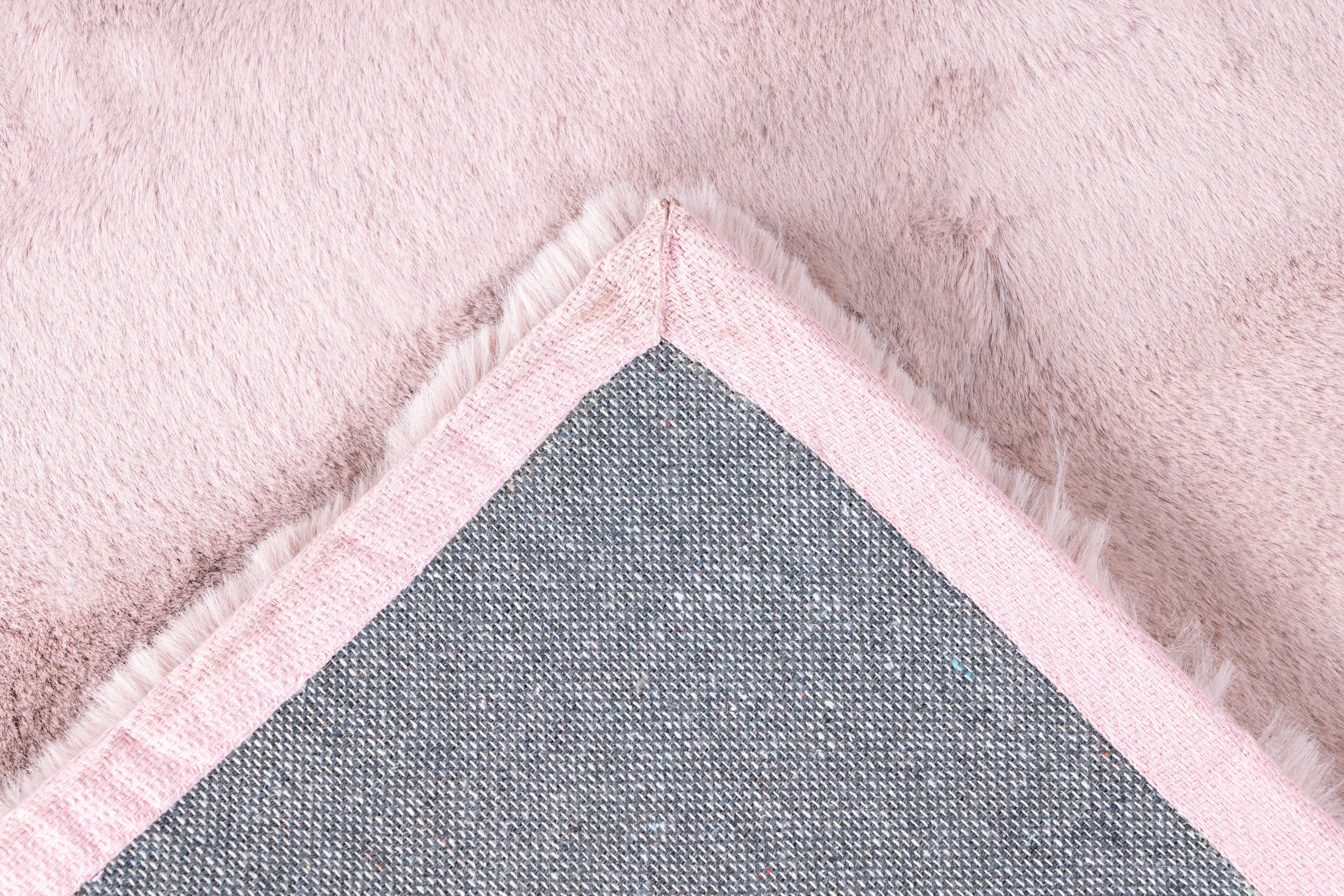 Detailfoto van de onderkant van het Cloud vloerkleed in zachtroze, met aandacht voor de afwerking