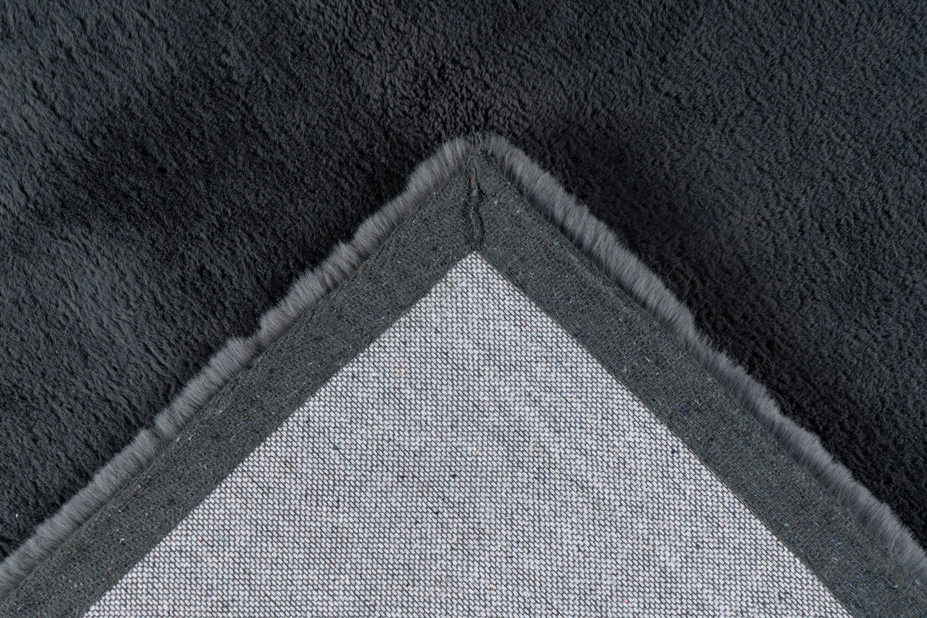 Detailopname van de onderkant van het Cloud vloerkleed in antraciet, met verzorgde afwerking