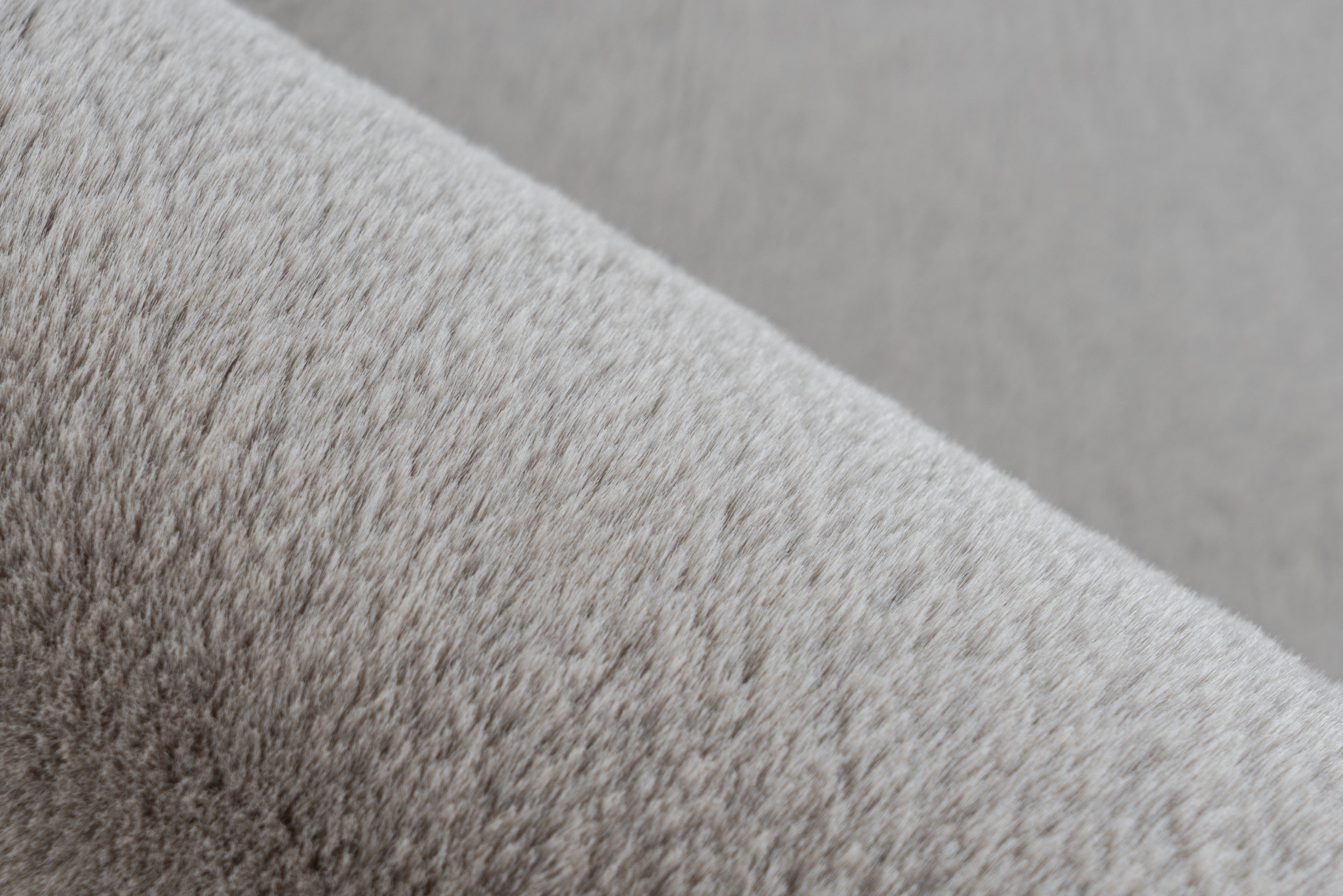 Ingezoomd op de fijne vezels van het taupe Could vloerkleed voor een comfortabele uitstraling