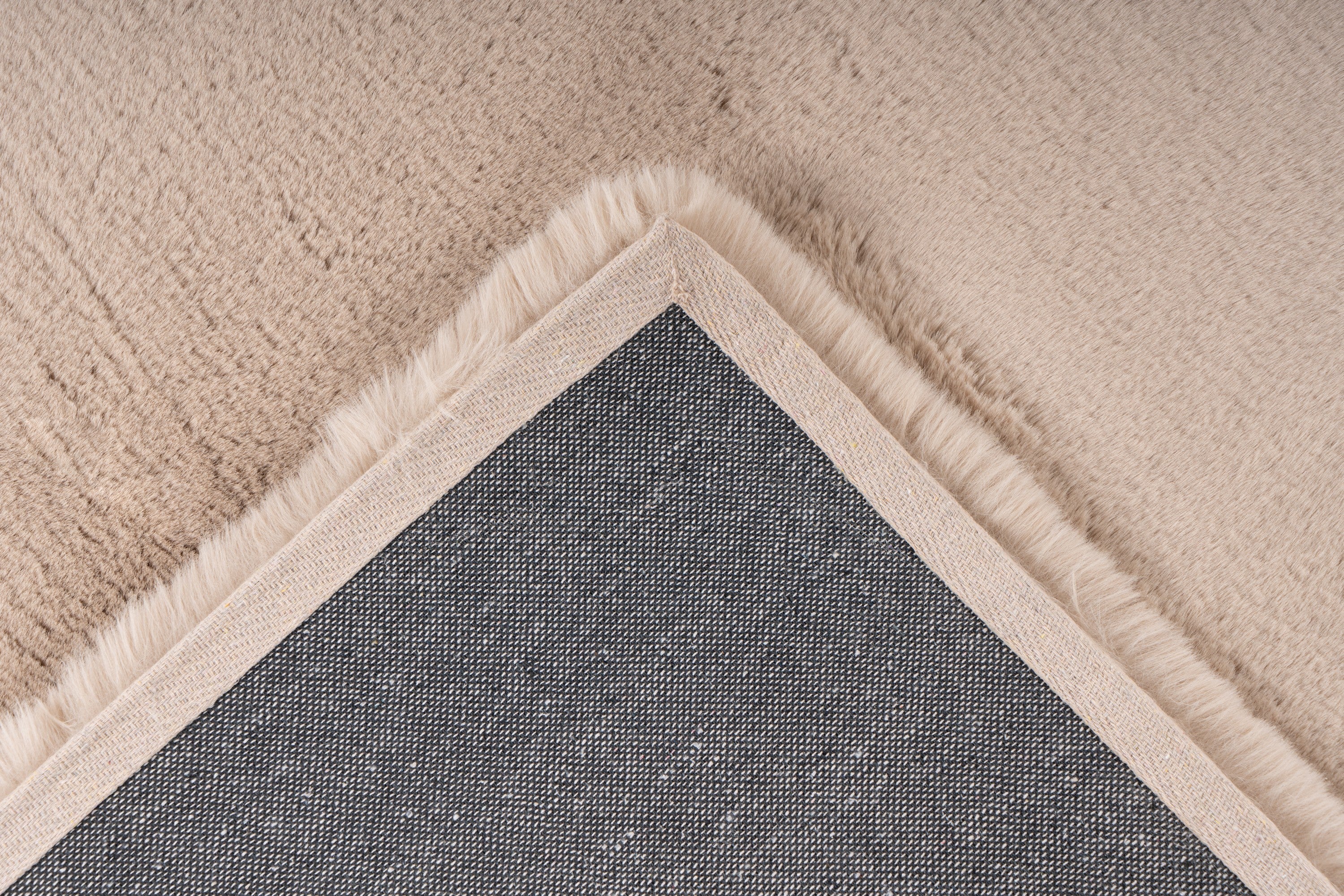 Detailfoto van de achterkant van het Eternelle vloerkleed in beige, met nette afwerking