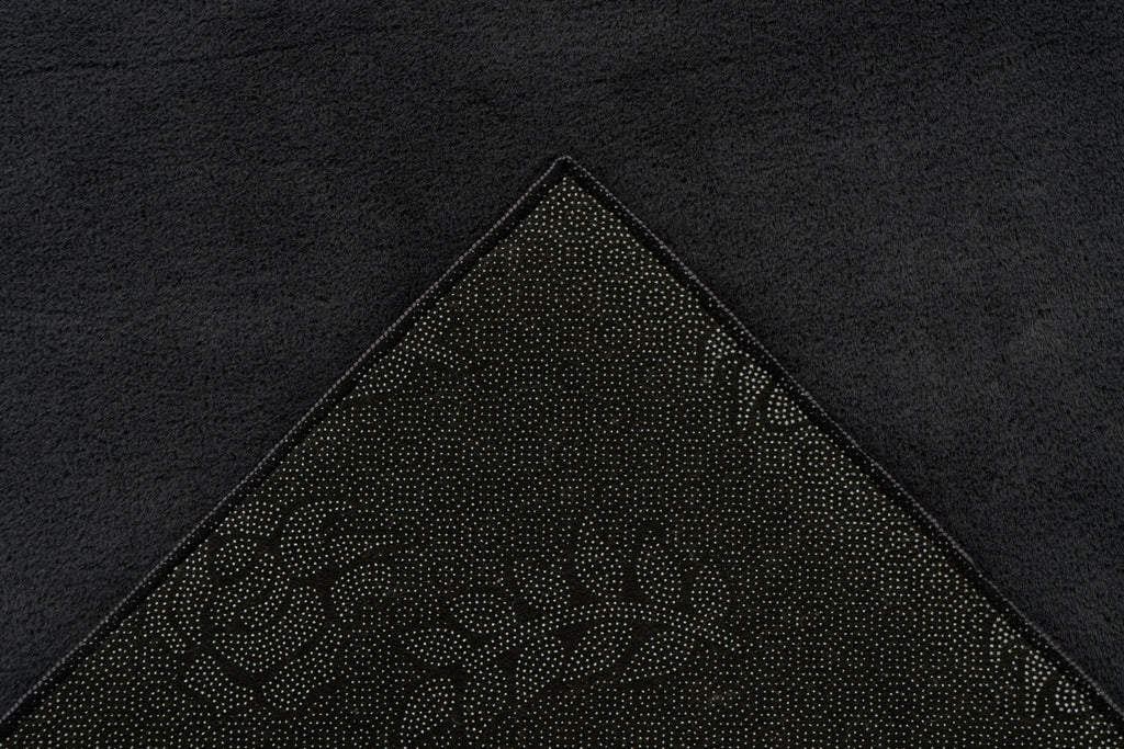 Detailhoek van vloerkleed met zicht op de backing – Softcare product op de achtergrond