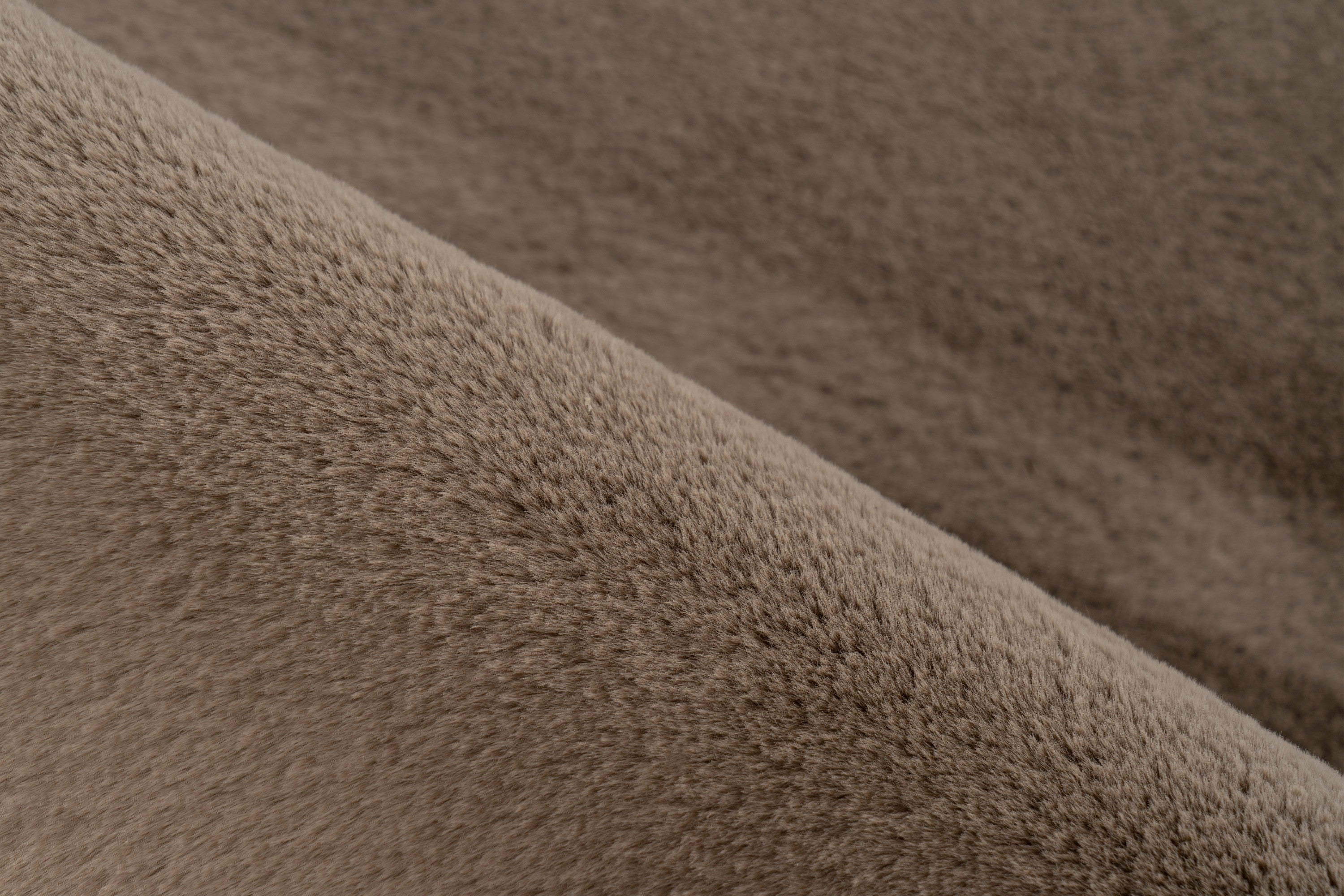Close-up van taupe vloerkleedvezels met zichtbare textuur