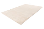 Zijaanzicht van het beige vloerkleed, waarbij je de zachte dikte goed kunt voelen