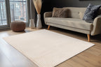 Het beige Lushlyn vloerkleed ligt sfeervol in een lichte woonkamer