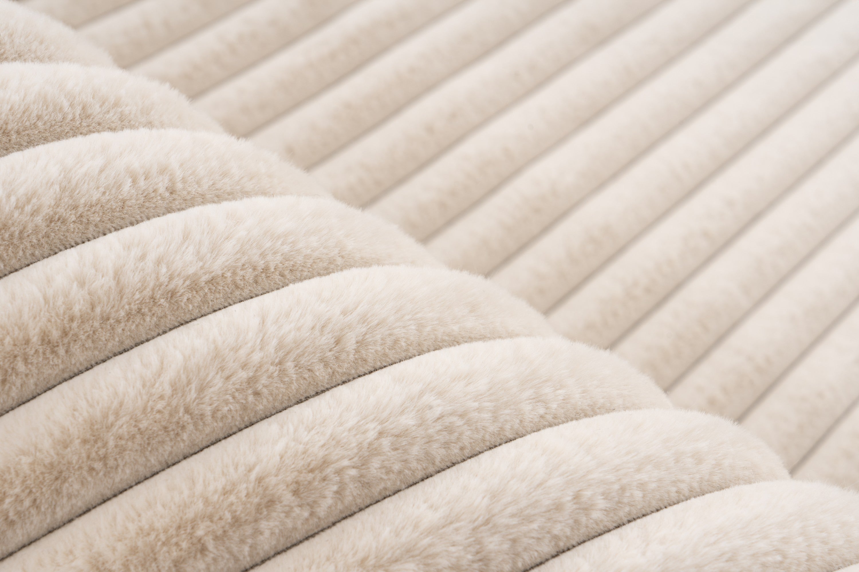 Ingezoomd op de fijne vezels van het beige Lushlyn vloerkleed, die het zo comfortabel maken