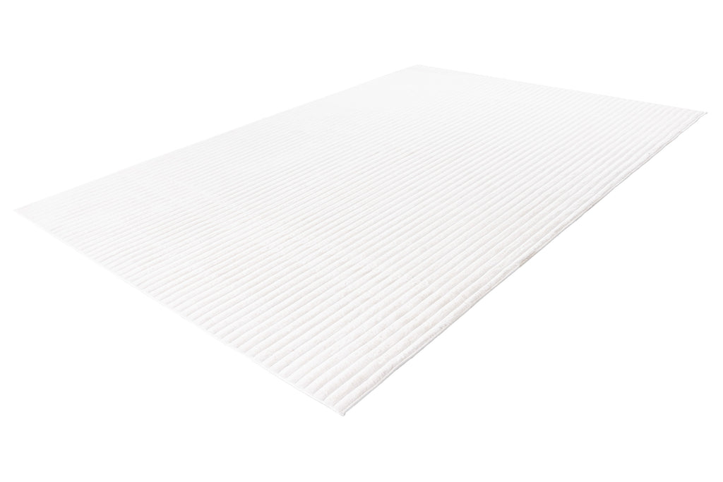 Zijaanzicht van het witte vloerkleed waarbij de zachte dikte goed zichtbaar is
