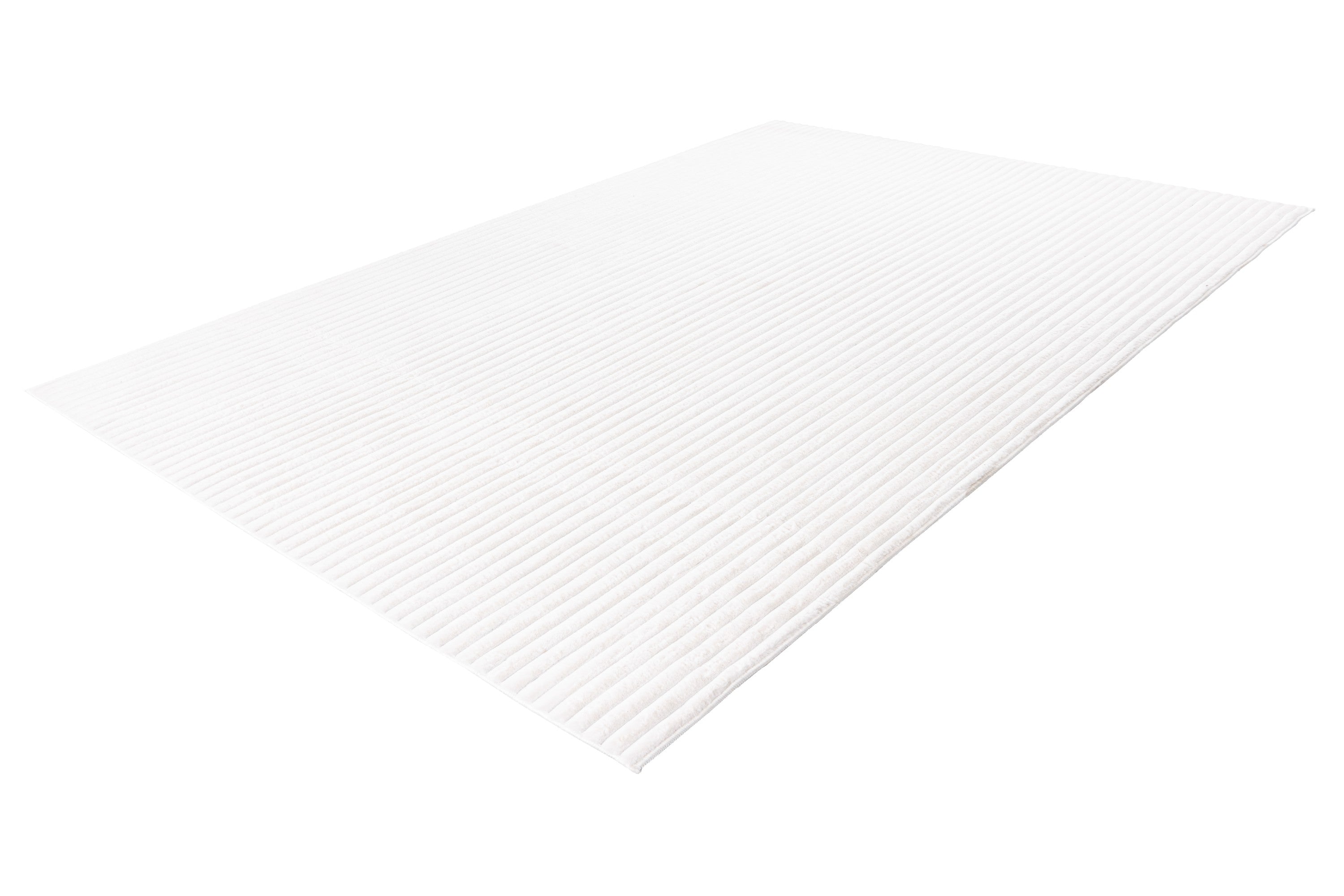 Zijaanzicht van het witte vloerkleed waarbij de zachte dikte goed zichtbaar is