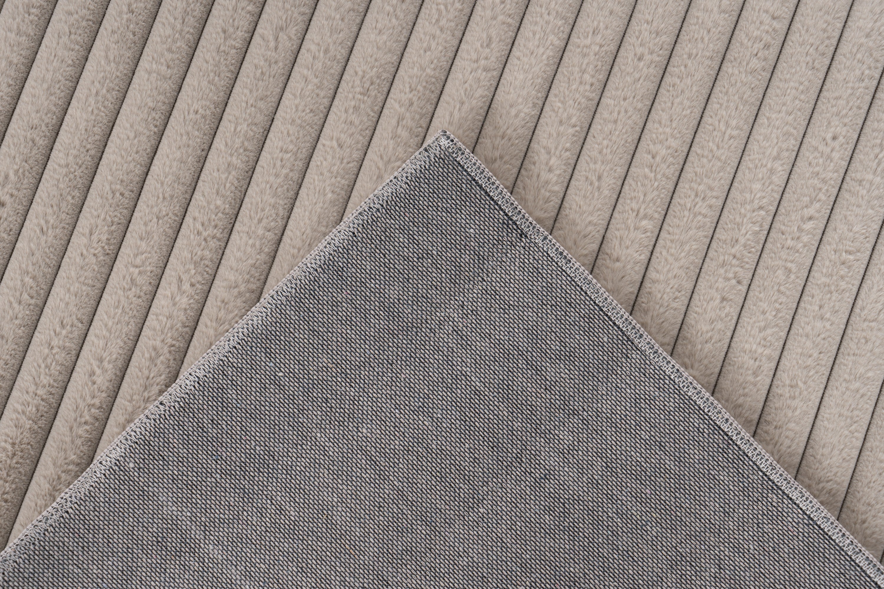 Ingezoomde hoek van taupe Lushlyn vloerkleed met zicht op backing en afwerking
