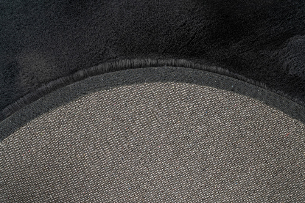 Close-up van de backing van het antraciet Maan vloerkleed met zicht op de afwerking
