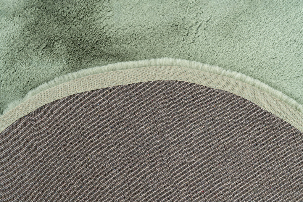 Close-up van de backing van het mosgroene Maan vloerkleed vanuit een hoekopname