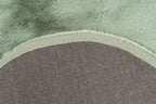 Close-up van de backing van het mosgroene Maan vloerkleed vanuit een hoekopname