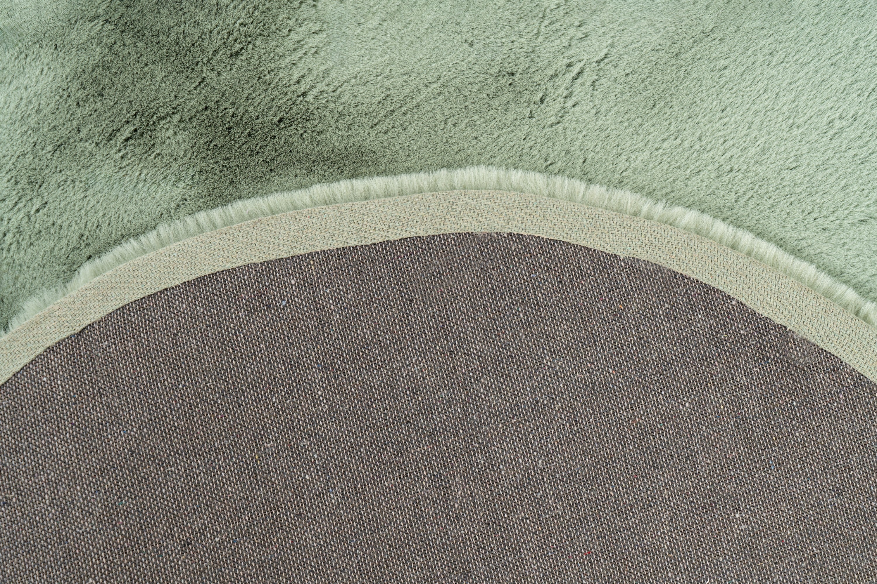 Close-up van de backing van het mosgroene Maan vloerkleed vanuit een hoekopname