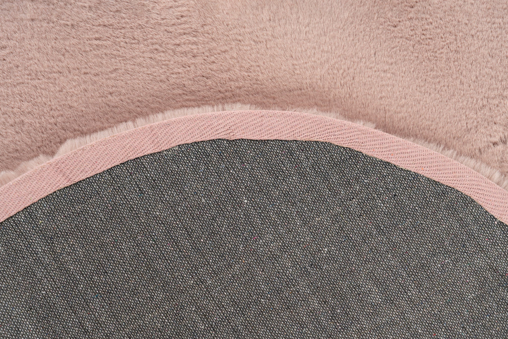 Detailshot van de onderkant van het Maan vloerkleed in zachtroze, met focus op de afwerking