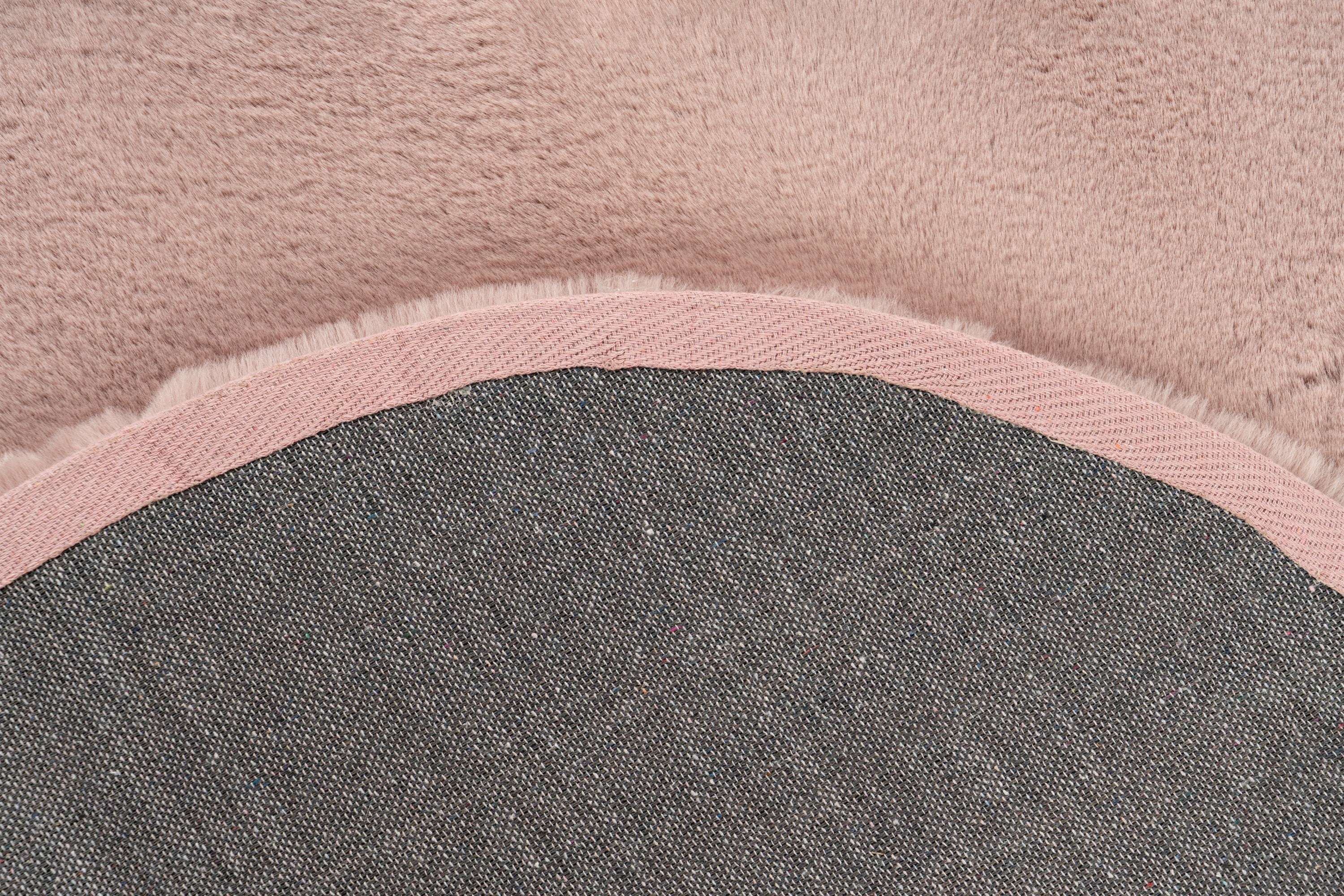 Detailshot van de onderkant van het Maan vloerkleed in zachtroze, met focus op de afwerking
