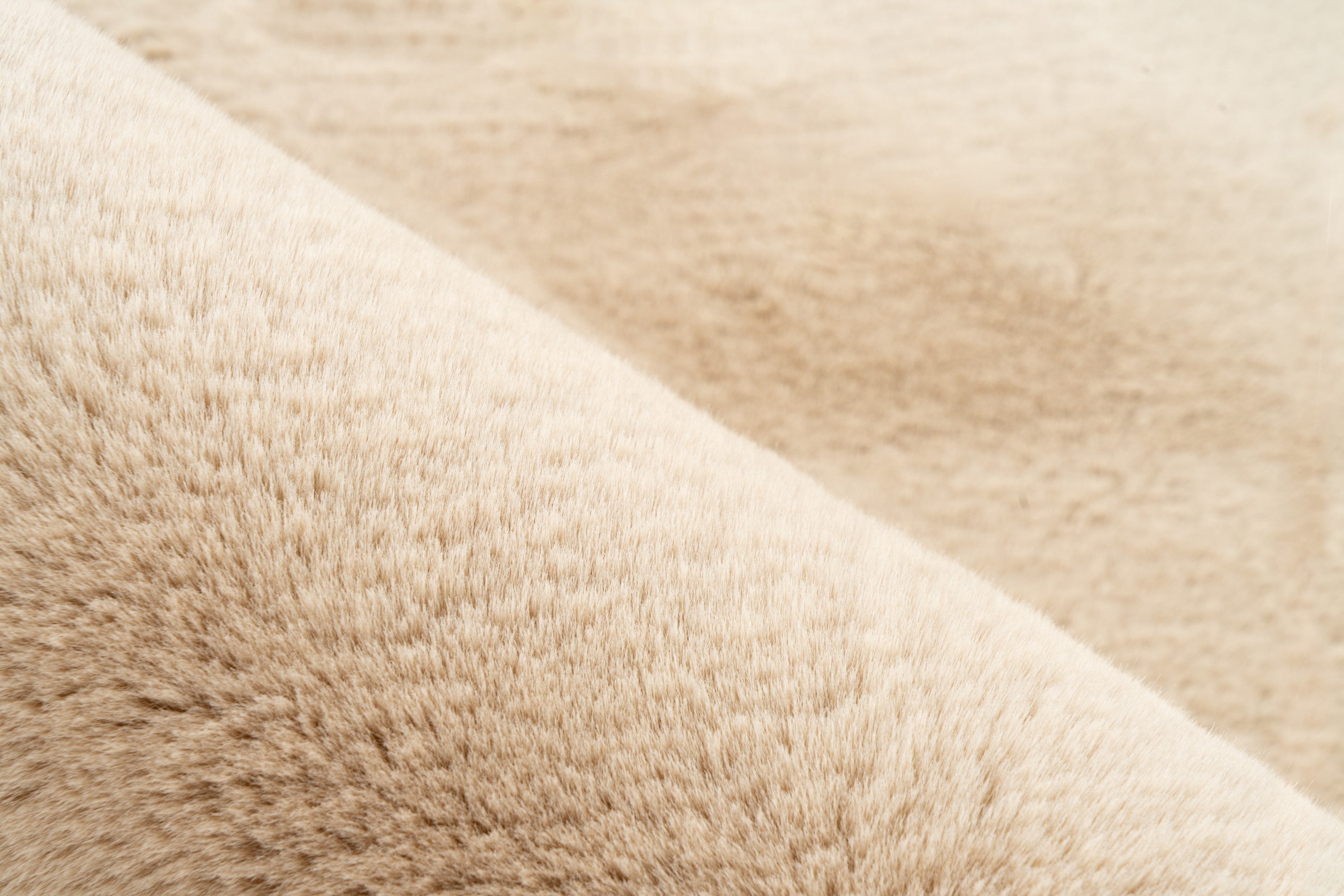Ingezoomd op de structuur en vezels van het zandbeige Maan vloerkleed