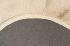 Detailopname van de achterkant van het zandbeige Maan vloerkleed met zicht op de afwerking