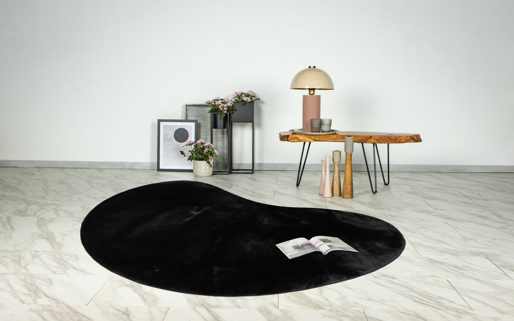 Organisch gevormd Maan zwart  vloerkleed als eyecatcher in een moderne woonkamer