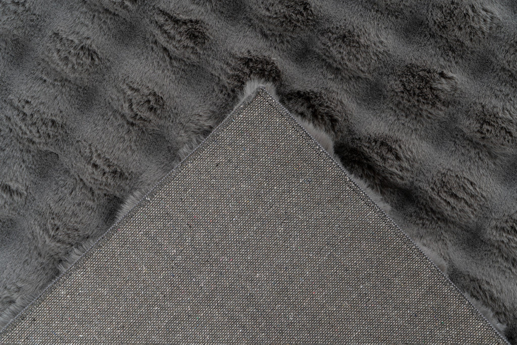 Close-up van een hoek van het antraciet Softedge vloerkleed met zicht op de backing