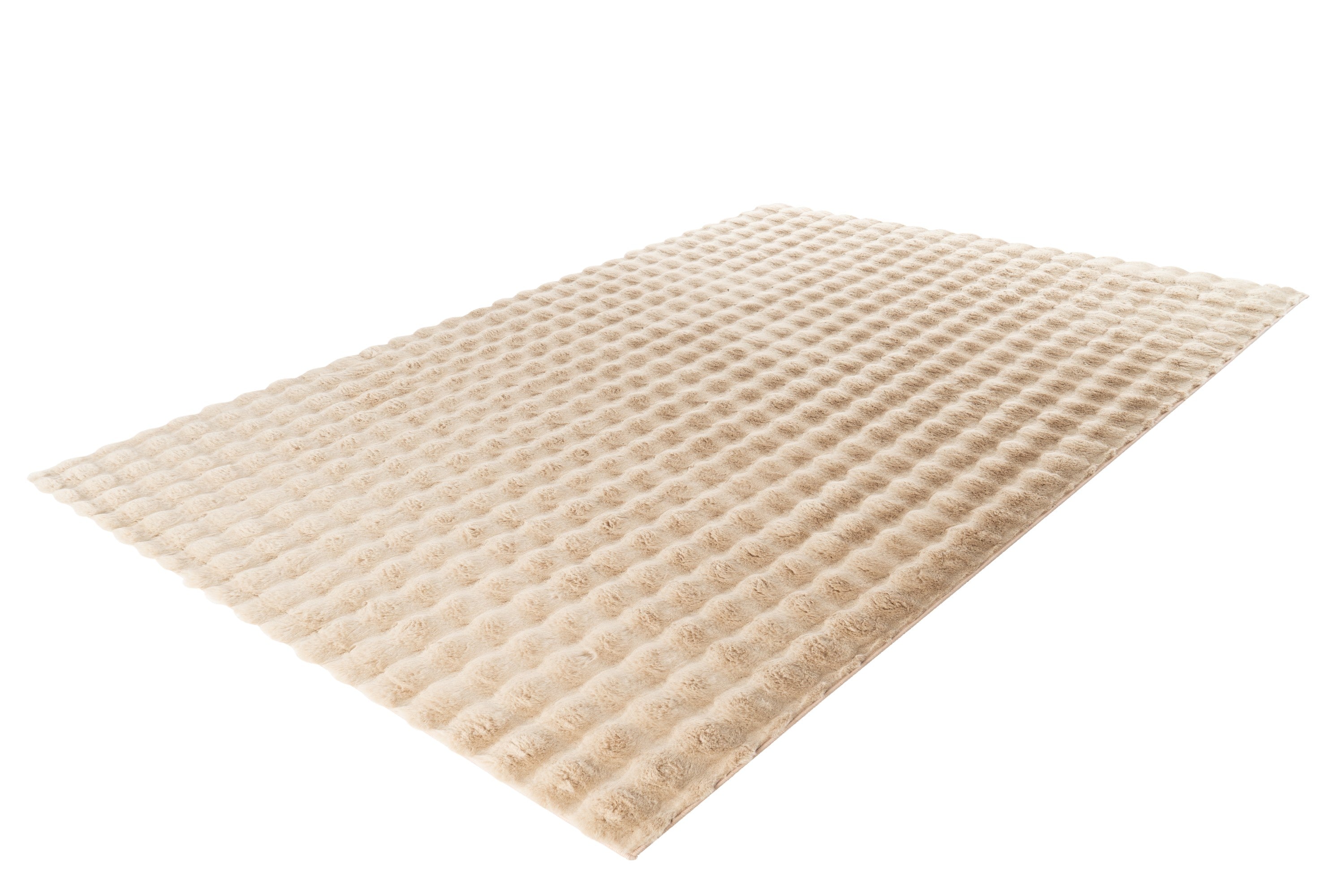 Zijaanzicht van het beige Softedge vloerkleed met zicht op de zachte textuur en dikte