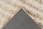 Close-up van een hoek van het beige Softedge vloerkleed met zicht op de backing