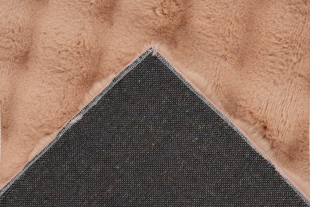 Close-up van een hoek van het perzik Softedge vloerkleed met zicht op de backing