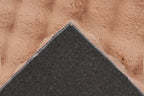 Close-up van een hoek van het perzik Softedge vloerkleed met zicht op de backing