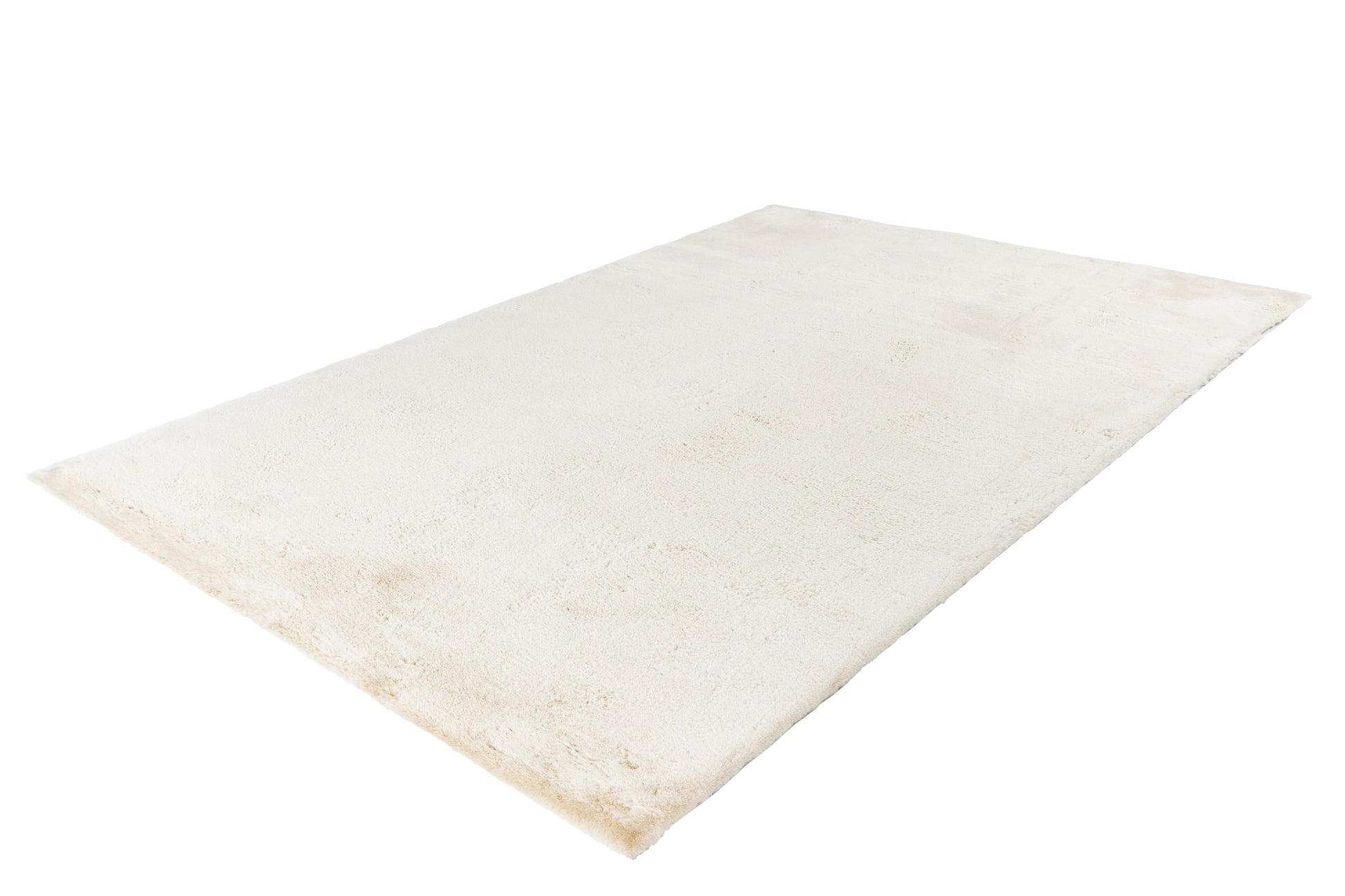 Zijaanzicht van het crème vloerkleed met zicht op de zachte dikte en structuur