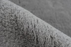 Close-up van een hoek van het grijze Vellyn vloerkleed met zicht op de backing