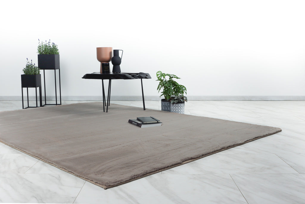 Het taupe Vellyn vloerkleed in een warme, gezellige woonkamer