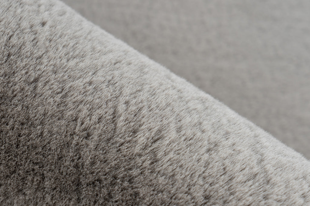 Ingezoomd op de zachte vezels van het taupe Vellyn vloerkleed voor optimaal comfort