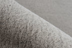 Ingezoomd op de zachte vezels van het taupe Vellyn vloerkleed voor optimaal comfort
